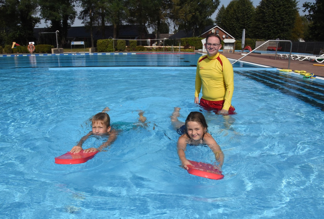 Ein BFD'ler bei der Schwimmausbildung mit zwei Kindern im Wasser